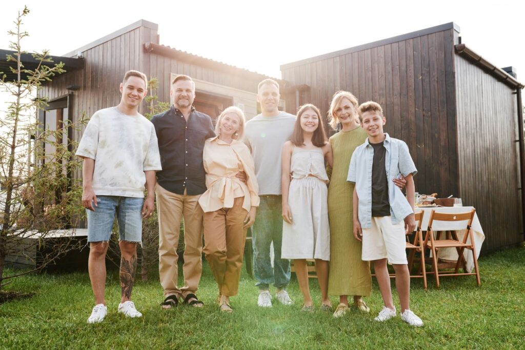 large white family posing in front of house